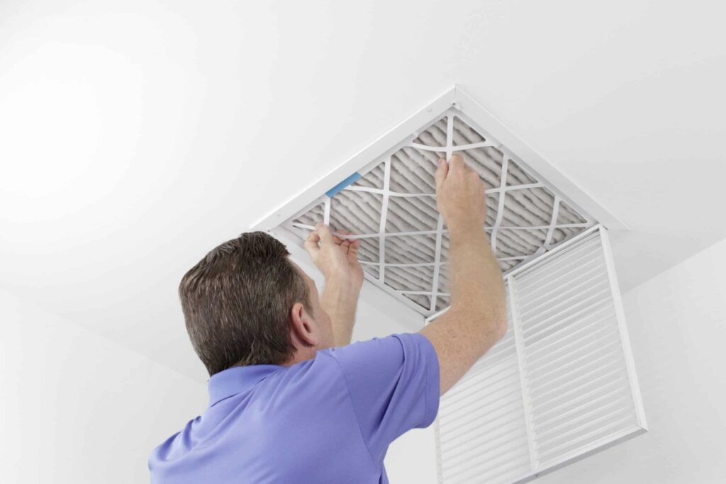 A worker changing an air filter vent of an air conditioner in Odgen & Brigham, UT
